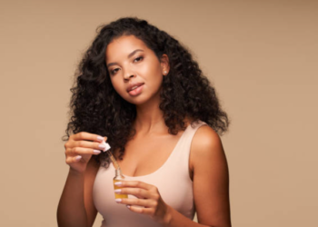 Black woman using a hair growth oil.