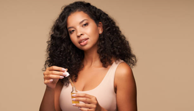 Black woman using a hair growth oil.