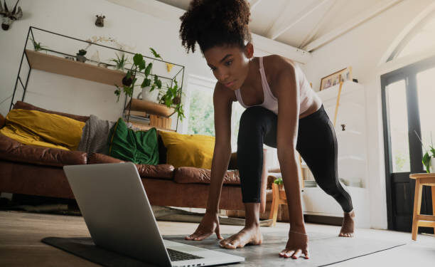 Black woman doing an at-home workout, building muscle in the comfort of her living room.