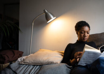 Black woman reading a book about breaking generational curses and living a life of love and healing.