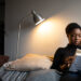 Black woman reading a book about breaking generational curses and living a life of love and healing.