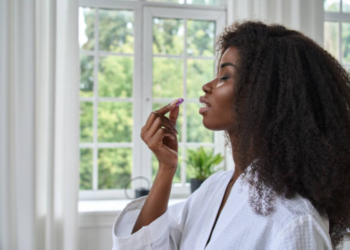 Black woman taking multivitamins and supplements for daily health and wellness.