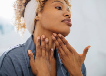 Black woman moisturizing her neck for anti-aging