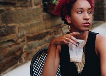 Black woman sitting at table alone after being ghosted.